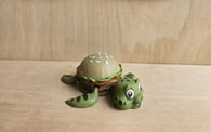 Burtle the Turtle in a burger bun